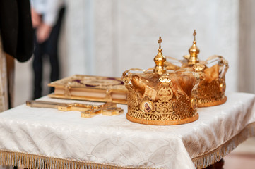 Fototapeta na wymiar Orthodox church golden crowns and cross on the table