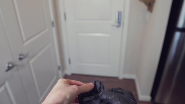 Putting on protective gloves and face mask to leave apartment quarantine during coronavirus pandemic