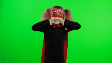 Funny child girl in costume and mask plays super hero. National superhero day