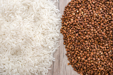 long rice and buckwheat on a wooden background. View from above.