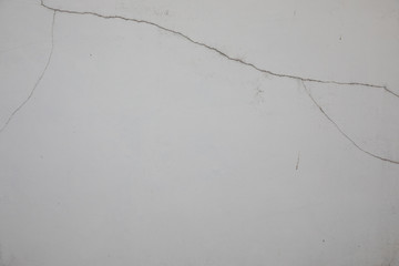 The white walls that have been left outside of the house for a long time show cracks, scratches and water marks. It looks empty and lonely, but beautiful and natural, suitable for making background.