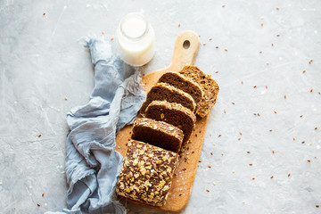 Sliced ​​bread on a board with milk. Tasty, beautiful homemade bread with grains. Homemade...