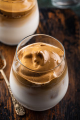 Dolgona coffee in glass cup. Korean trendy drink from instant coffee, milk and ice.