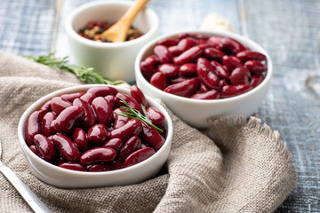 Red kidney beans from can in white bowl on a table.
