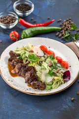 Salad with Chicken Liver, lettuce and beans on blue background