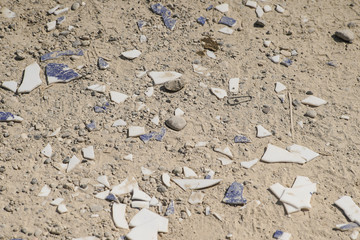 Scherben und Müll im Sand als Hintergrund