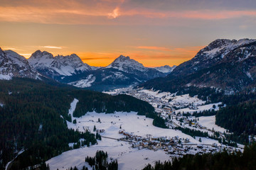 snowy city in italian alps at sunset