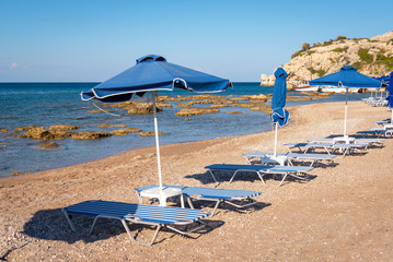 Sun loungers with umbrella on beautiful Kolymbia beach. Rhodes island, Greece