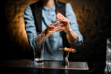 clear transparent glass and steel jigger with canapes stand on bar counter