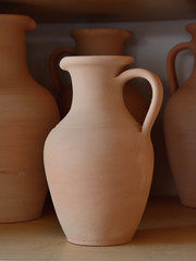 Fototapeta na wymiar Ceramic craft jug made by a Potter, against the background of other clay products