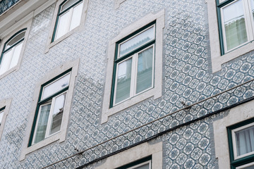 Azulejo - Portuguese and Spanish ceramic tiles on the facade with windows building in Lisbon Portugal