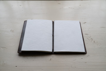 Leeres Lederbuch, Tagebuch auf altem weissen Holztisch