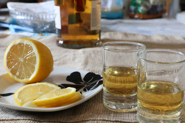 Glasses with whisky and lemon slices on the table.  Selective focus.