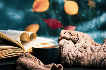Cup of coffee and fallen autumn leaves on the window