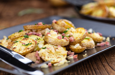 Portion of Fried Potatoes on an old wooden table (selective focus; close-up)