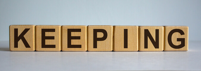 Fototapeta premium Concept word 'keeping' on cubes on a beautiful white background.