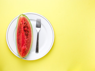 Sliced Watermelon on white plate with spoon and fork stock photo with bright background.
