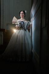 Beautiful girl, in a romantic dress, retro style.With dark hair. Stands against the background of...