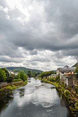 Fototapeta na wymiar View of the river Dordogne at Bort les Orgues, a little french village in Correze, Auvergne. The beauty of the river in a very cloudy day.