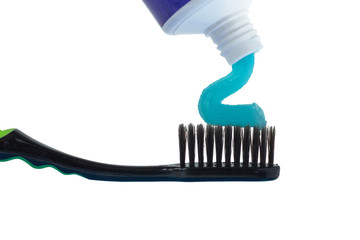 White blue toothpaste lies beautifully on a black toothbrush isolated on white background. Tooth brushing concept.