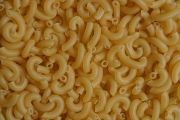 yellow natural background of dried small pasta in a heap