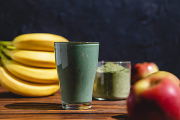 promotional shooting of a fruit cocktail for a healthy eating establishment. In the photo, a glass with a green drink made from fruits and algae spirulina powder