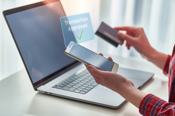 Person using laptop, plastic credit card and mobile phone for online shopping, paying goods and transaction. Modern people using e commerce and mobile payment banking