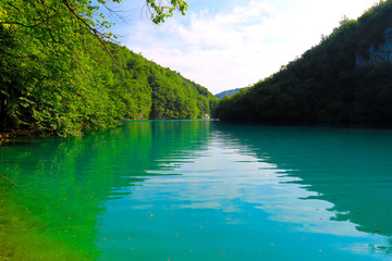 Beautiful picturesque Plitvice Lake in the Croatian National Park. Clean green water in the small mountain river. Natural water background in lake, water scarcity and resources. Croatia.