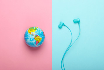World song. Global music chart. The music of earth. Stereo earphones and a globe on pink blue...