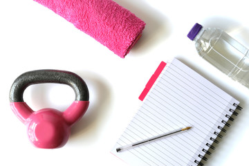 Healthy life style pink accessories on white background, top view, flat lay. Diet and fitness concept, rerecording achievements vs goals, setting goals