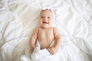Cute baby in a blanket,smiles and laughs