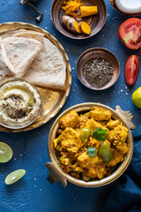 Oriental food - Indian paneer sabji with chapati and sauce. indian cuisine. Indian Curry in copper brass with ingredients in blue background top view close-up, Set of Indian food.
