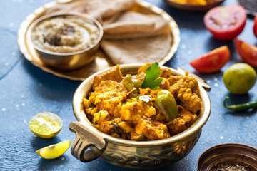 Oriental food - Indian paneer sabji with chapati and sauce. indian cuisine. Indian Curry in copper brass with ingredients in blue background close-up, Set of Indian food.