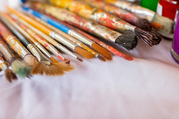 Fototapeta premium Paintbrush placed on a white cloth, Art Education, Learning to the 21st century, Stem studies.Selectively focus on specific points and blur in the image.