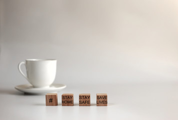 Words  Stay Home, Stay Safe, Save Lives on wooden blocks, concept of self quarantine at home as preventative measure against virus outbreak. Wooden cubes on white background