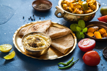 Oriental food - Indian homemade bread chapati and sauce. indian cuisine. Indian Curry in copper brass with ingredients in blue background close-up, Set of Indian food.