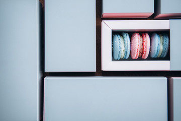 French cookies of different colors are packed in rectangular packages. Copy space