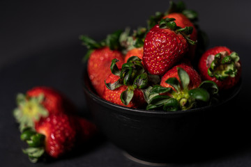 Black bowl with fresh strawberries