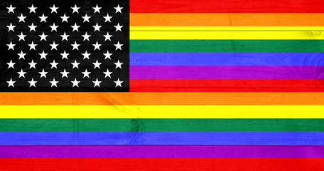 A rustic old USA pride flag on weathered wood for a background. Gay America.