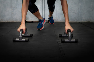 Young man exercises on the floor with parallel