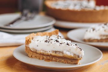 appetizing slice of sand-based dessert with white cream cheese and banana stuffing sprinkled with grated chocolate