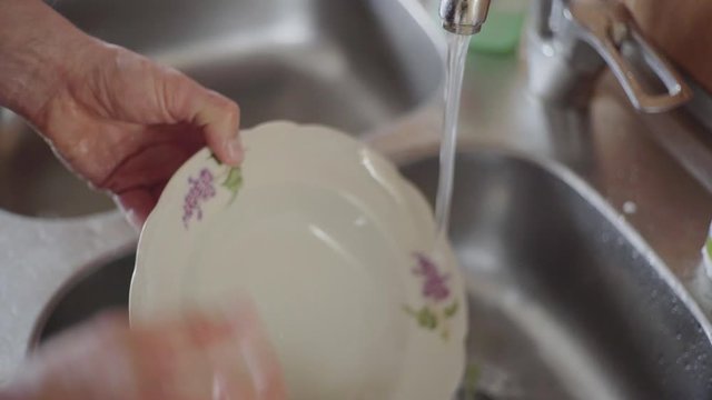 A man washes dishes in the kitchen