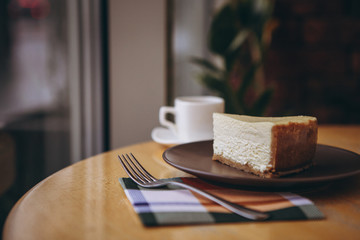 Piece of cake with coffee for breakfast on the table in a coffee shop