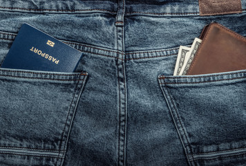 Passport and wallet with dollars in the back pockets of jeans. Travel or immigration concept