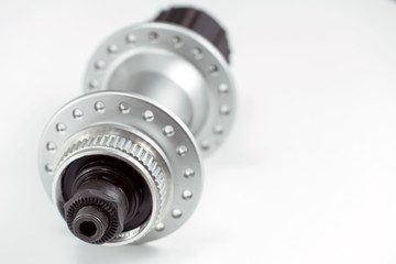 Bicycle repair. Mountain bike workshop. Rear hub under the disc brake on a white background. The body is silver. Spare parts for a bicycle of a famous manufacturer and brand.