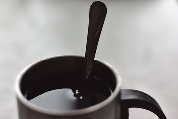 spoon in a metal cup with tea