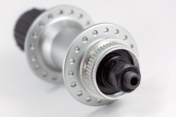 Bicycle repair. Mountain bike workshop. Rear hub under the disc brake on a white background. The body is silver. Spare parts for a bicycle of a famous manufacturer and brand.