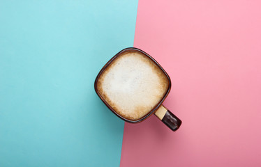 Cup of latte or cappuccino on pink blue pastel  background. Coffee with milk. Top view