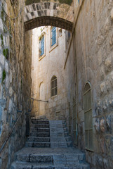 The old city street in Jerusalem, Israel. A stone arch in the wall of the house, empty stairs in the daytime.