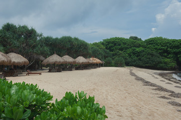 Fototapeta premium Beach umbrellas from straw on tropical sandy beach.